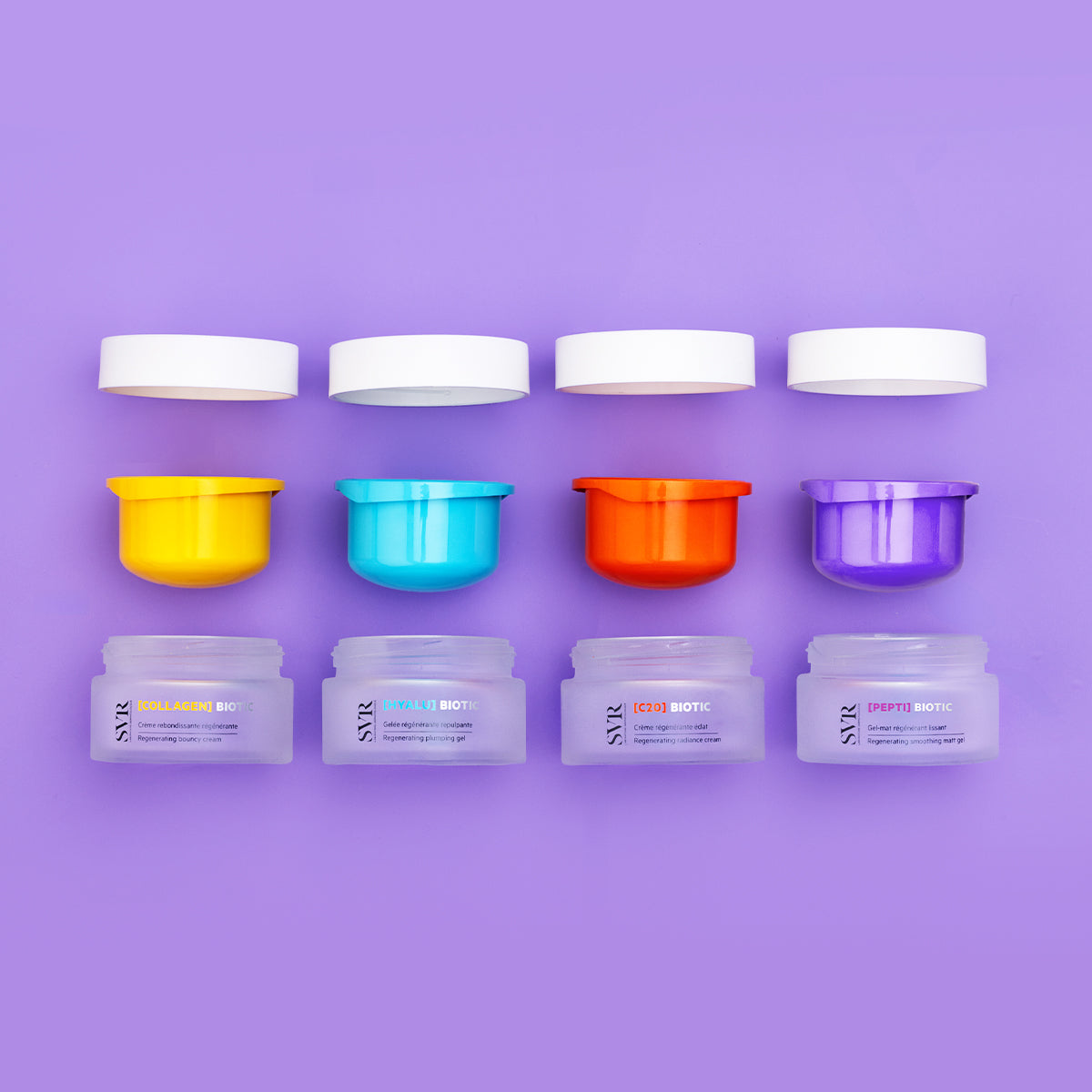 Four SVR Biotic skincare jars with colorful inner lids and white caps arranged on a purple background.