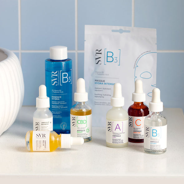 Collection of SVR skincare ampoules and a sheet mask featuring various colored glass dropper bottles on a white surface.