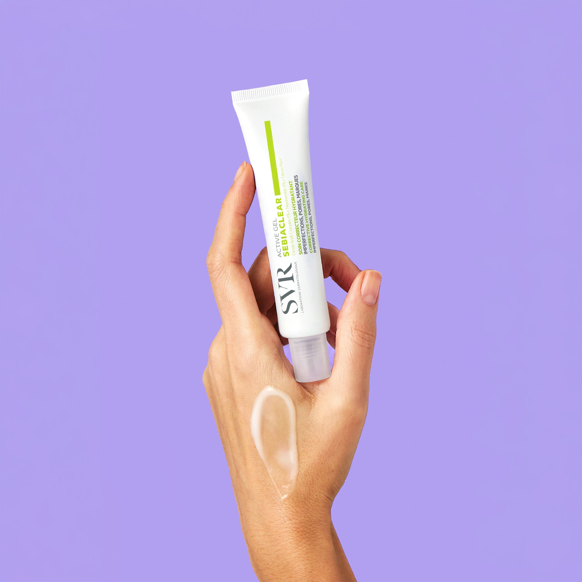 Hand holding a white SVR Sebiaclear Active Gel tube against a purple background with a gel swatch on the skin.