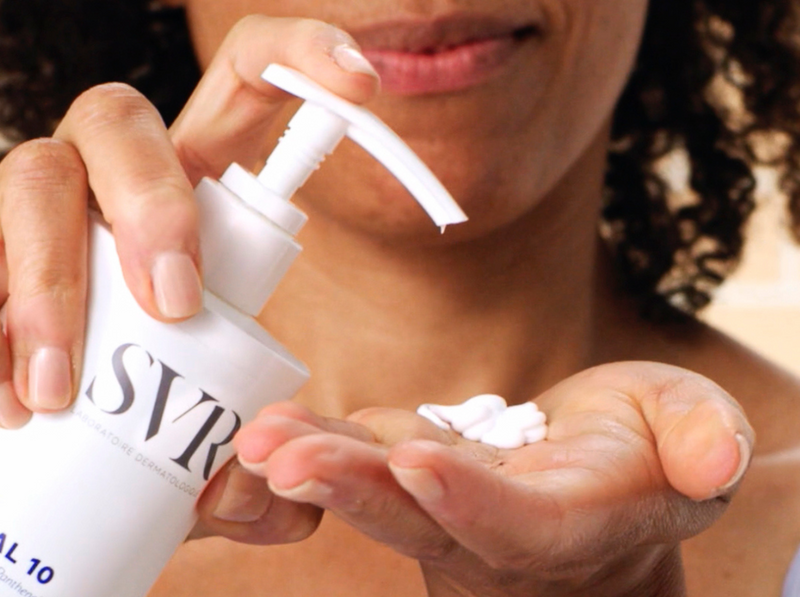 Person applying white moisturizing cream from a pump bottle onto their palm to treat skin keratosis.