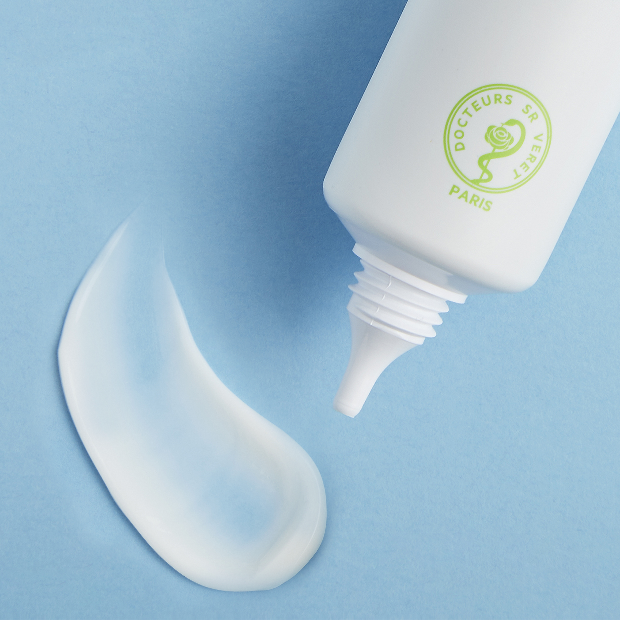 White squeeze tube of Sebiaclear Mat+Pores Cream with cream swatch on blue background.